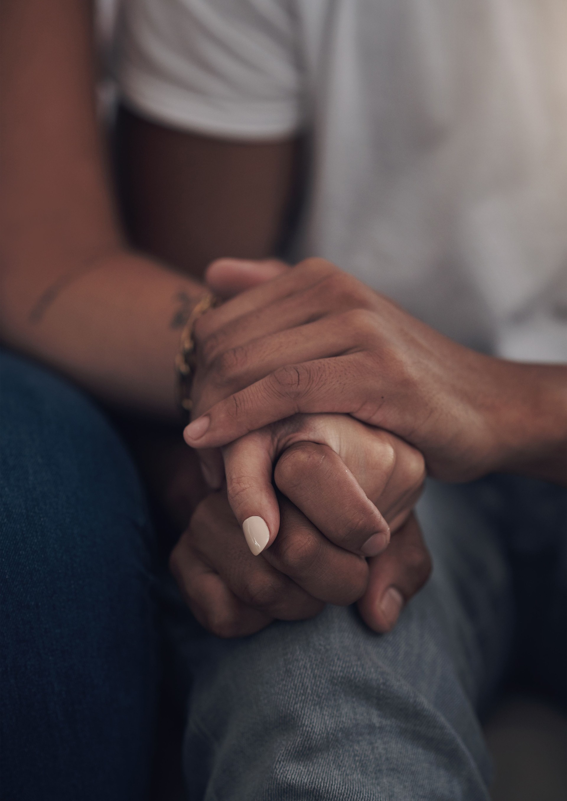 Cropped shot of an unrecognizable couple sitting inside together and holding hands